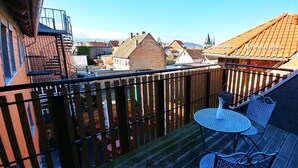 A balcony with a metal railing, a small round table, and a chair. - Hotel Alte Brennerei (Wernigerode)