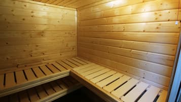 Una sauna de madera con bancos y techo inclinado.