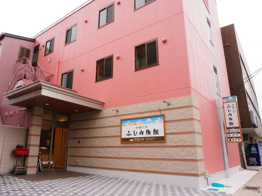 A pink building with a sign indicating a Front Desk.