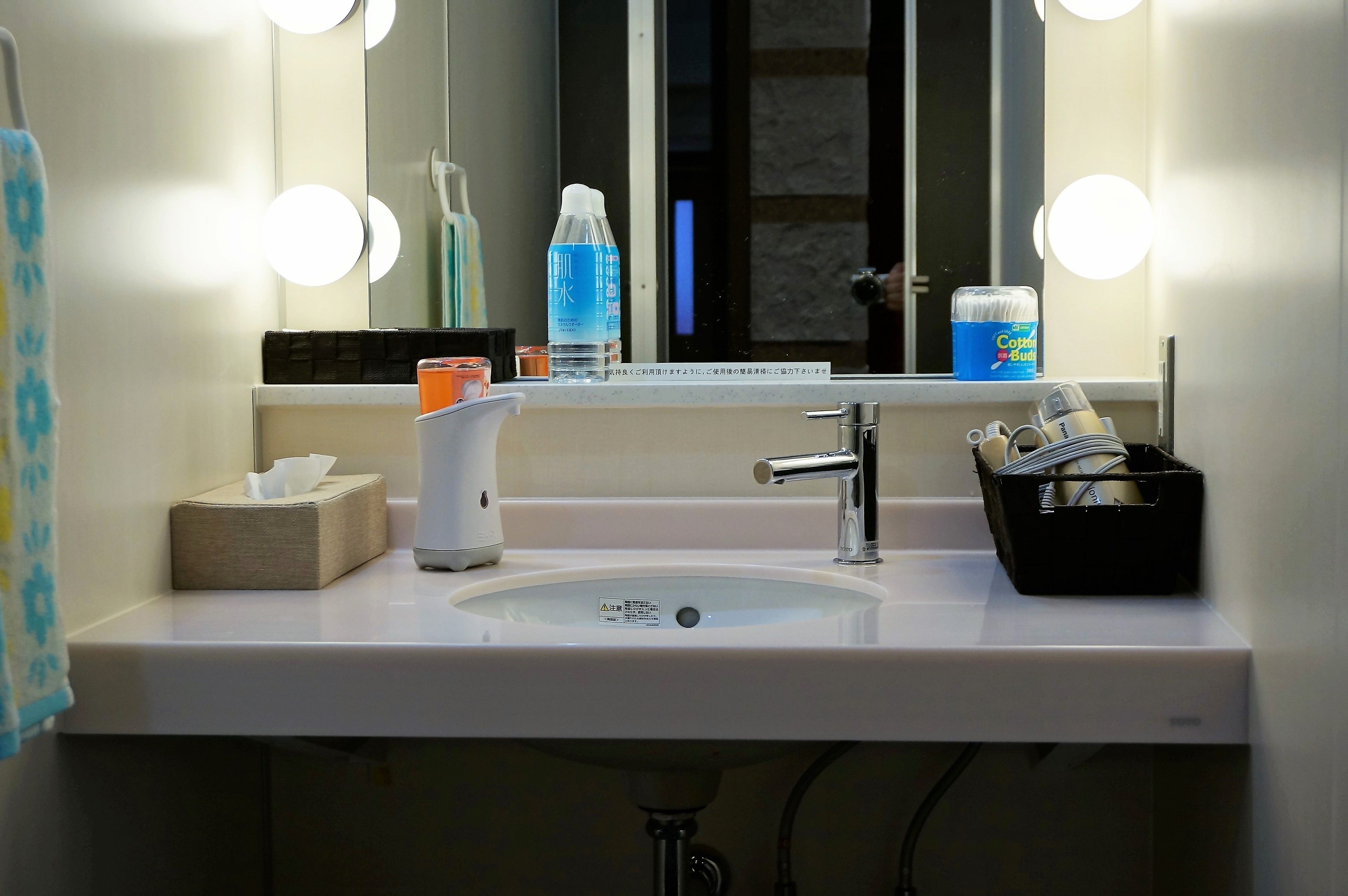 Une salle de bain d’hôtel avec un lavabo, un miroir et des luminaires.