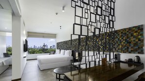 A modern hotel room with a large bed, a dining area, and a city view. - ME Colombo (Colombo)