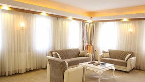 Una sala de estar moderna con dos sofás color beige, una mesa de centro blanca y una lámpara.