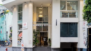 El exterior del Hotel Hammock, con una entrada despejada, un cartel y un hidrante en la acera.
