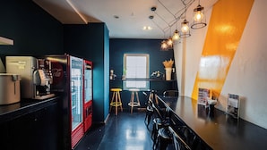 Una cocina moderna con encimera negra, refrigerador rojo y ventana con vistas.