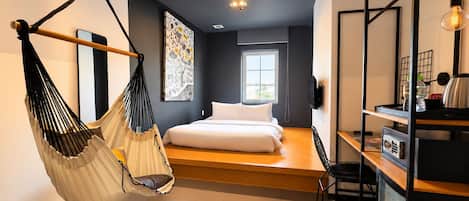 A modern bedroom with a hanging chair, a bed, a desk, and a large window.