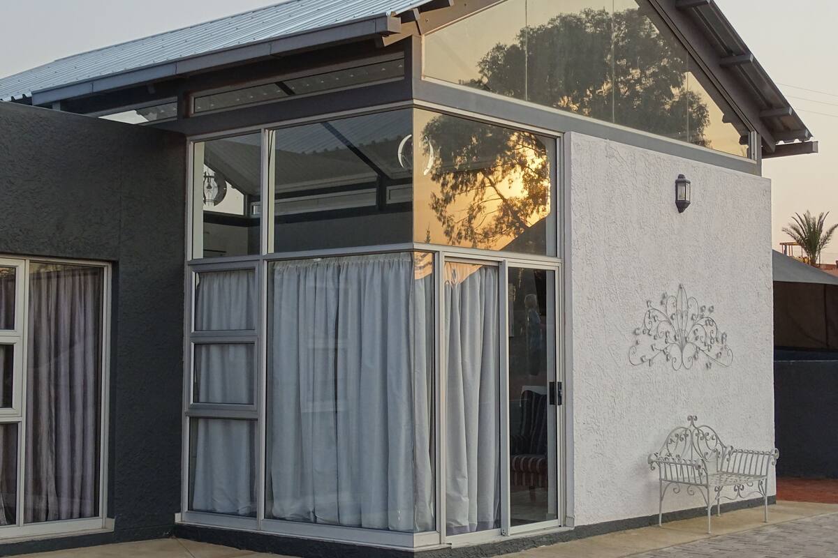 A modern building with large windows, a metal roof, and a decorative wall design.