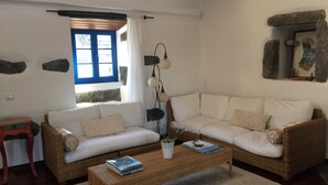 Una sala de estar con un sofá, una mesa de centro y una ventana con cortinas.