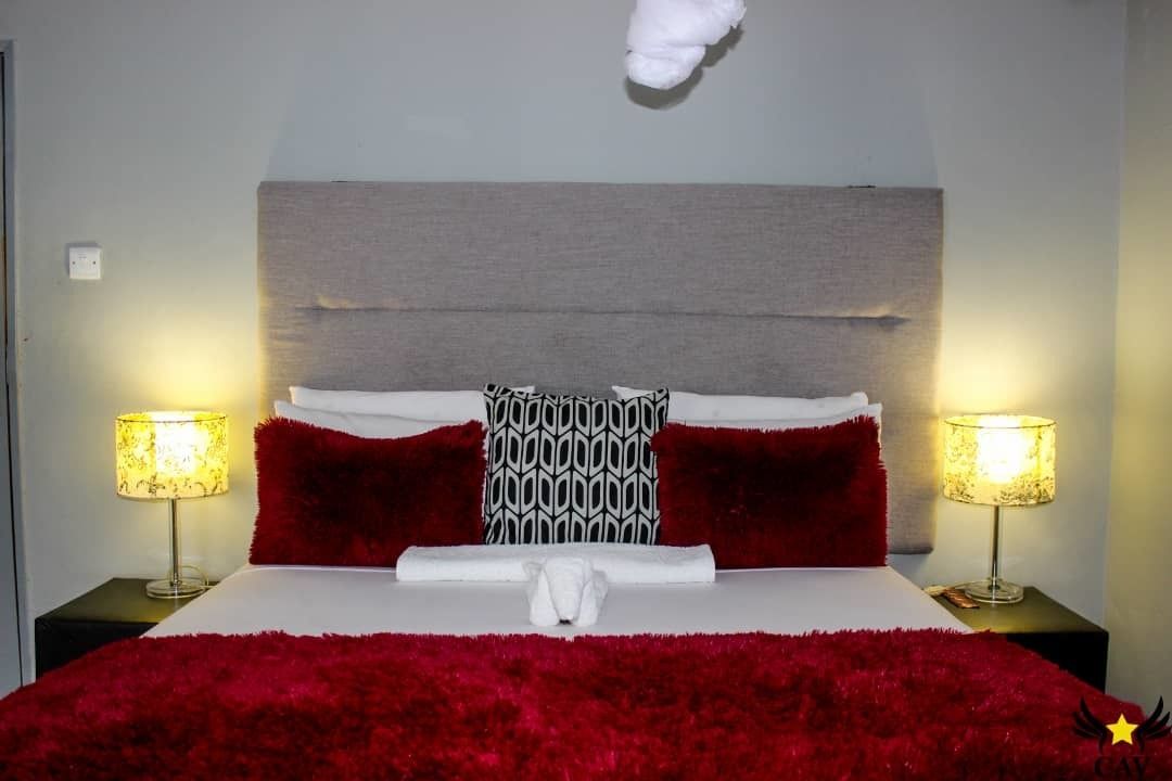 Une chambre d’hôtel avec un grand lit, deux lampes de chevet et une tête de lit.