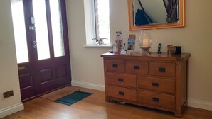 A wooden dresser with multiple drawers, a candle on top, and a framed mirror above it. - Mill Lodge Brecon Beacons (Abergavenny)