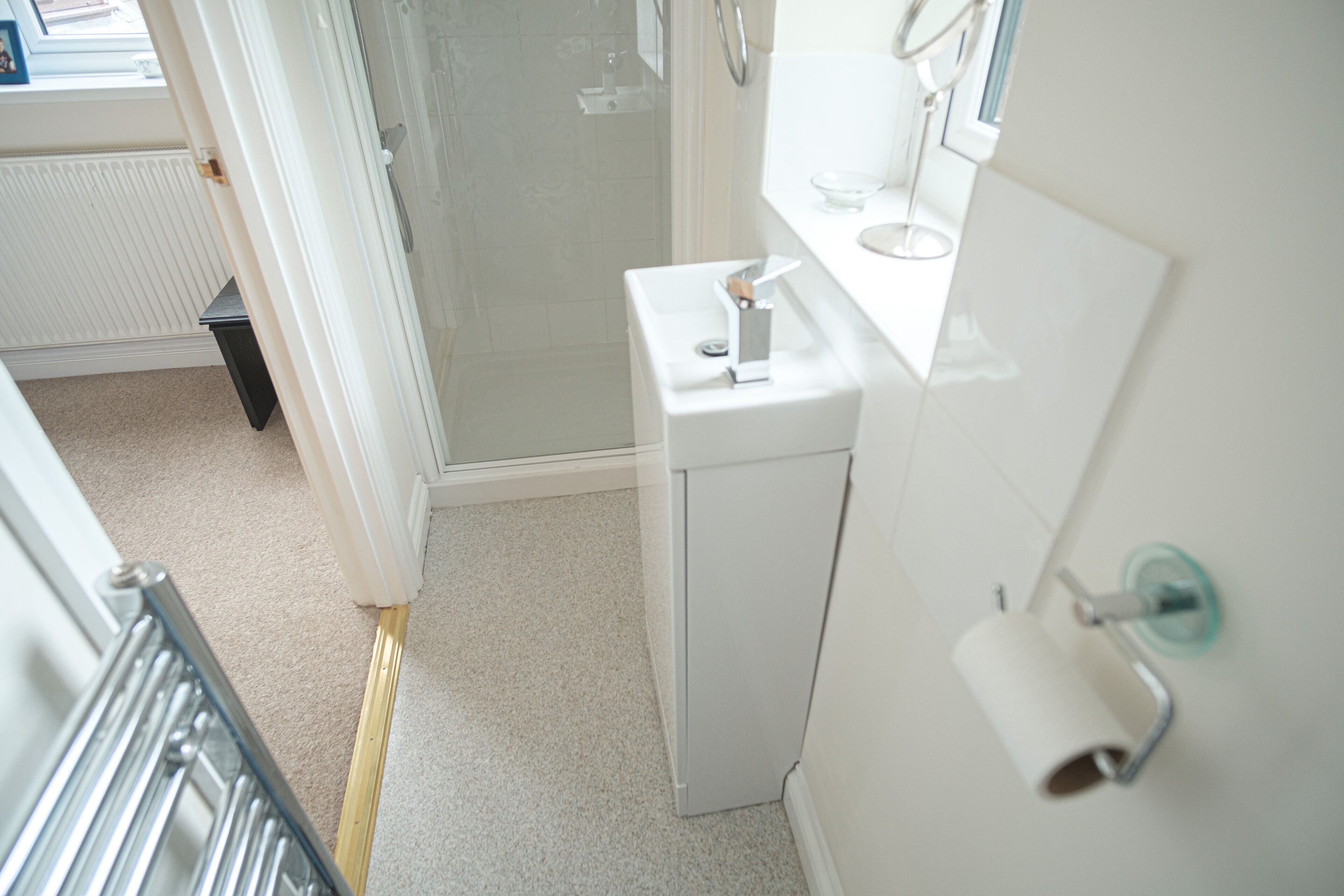 A bathroom with a white sink, a mirror, and a shower area.