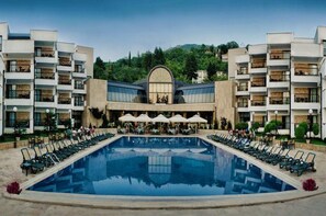 A hotel with a central pool, outdoor seating, and a mountainous backdrop. - Sileks Hotel (Ohrid)
