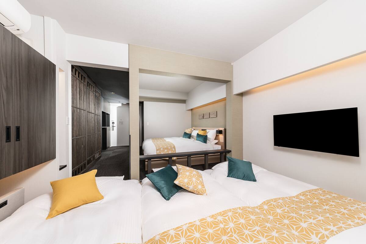 Une chambre d’hôtel avec deux lits, une télévision et une armoire.