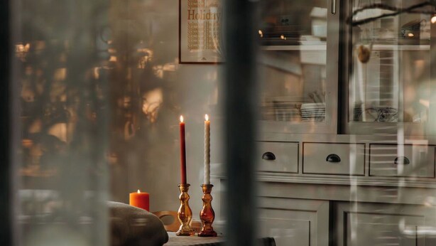 A view through a window with a table, candles, and a framed menu. - Bergen1928 (Bergen)