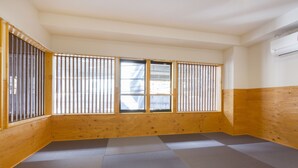 A room with tatami flooring, wooden walls, and shoji screens. - Guest House Koenji Junjo Hotel (Tokyo)