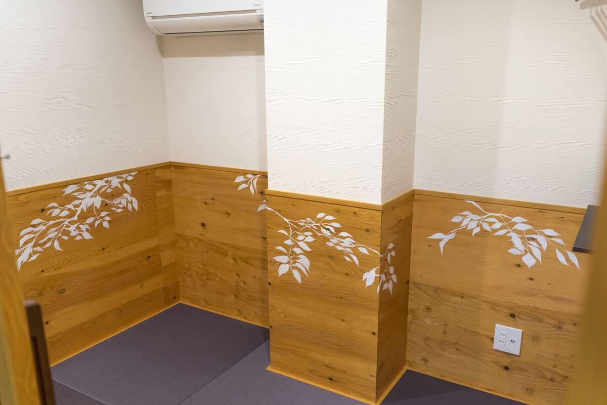 Ein Eckbereich eines Raumes mit Holzvertäfelung und einer weißen Wand.