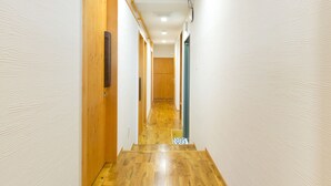 A narrow hallway with wooden flooring and white walls. - Guest House Koenji Junjo Hotel (Tokyo)