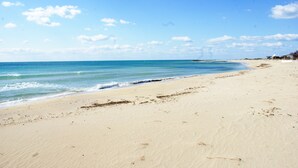 A wide sandy beach with gentle waves and a clear blue sky. - B&B Erminia (Presicce-Acquarica)