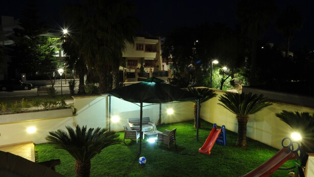 A nighttime outdoor area with a covered seating area, a slide, and artificial lighting. - B&B Erminia (Presicce-Acquarica)