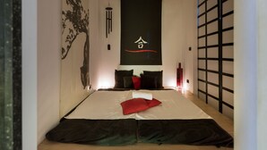 Una habitación de hotel moderna con una cama grande, una obra de arte en la pared y una puerta corredera.