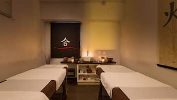 Relax in a serene spa room with two comfortable beds, a soothing table setting, and a calming ambiance.
