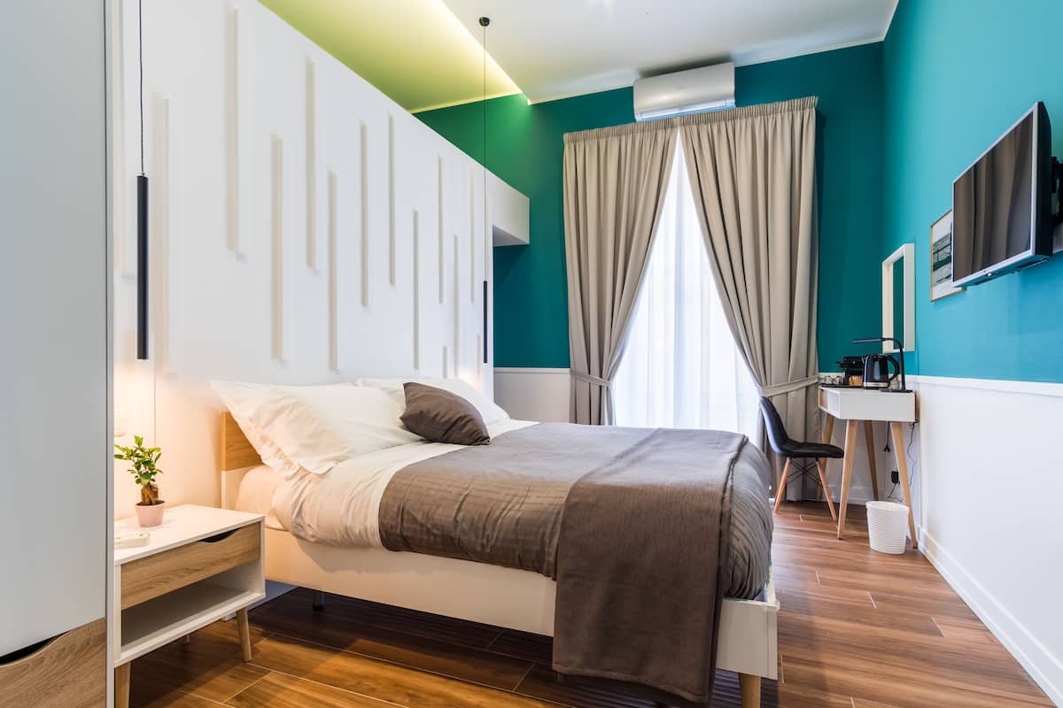 Ein modernes Schlafzimmer mit einem Bett, einem Nachttisch und einem Schreibtisch mit Stuhl.