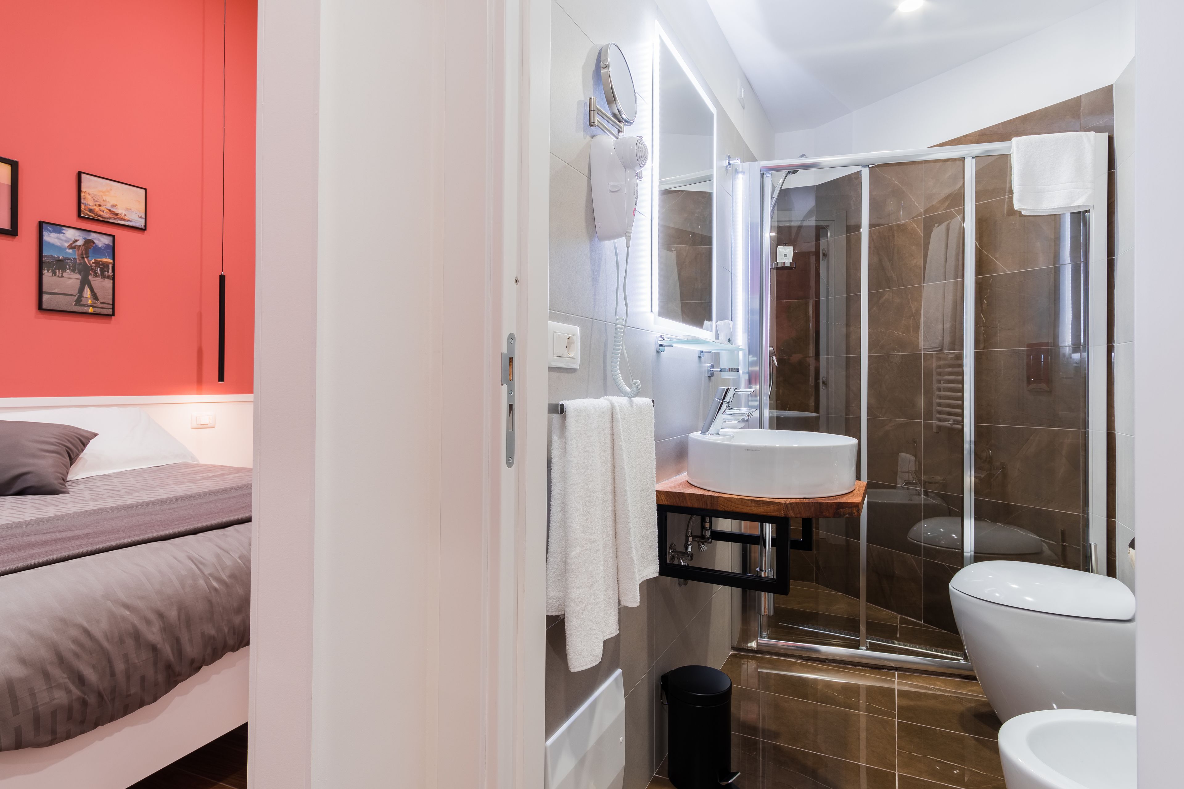 A modern bathroom with a glass shower enclosure, a white sink, and a mirror above it.