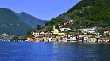 Stunning lakeside town with charming homes and a church, nestled among lush green hills and offering serene lake views.