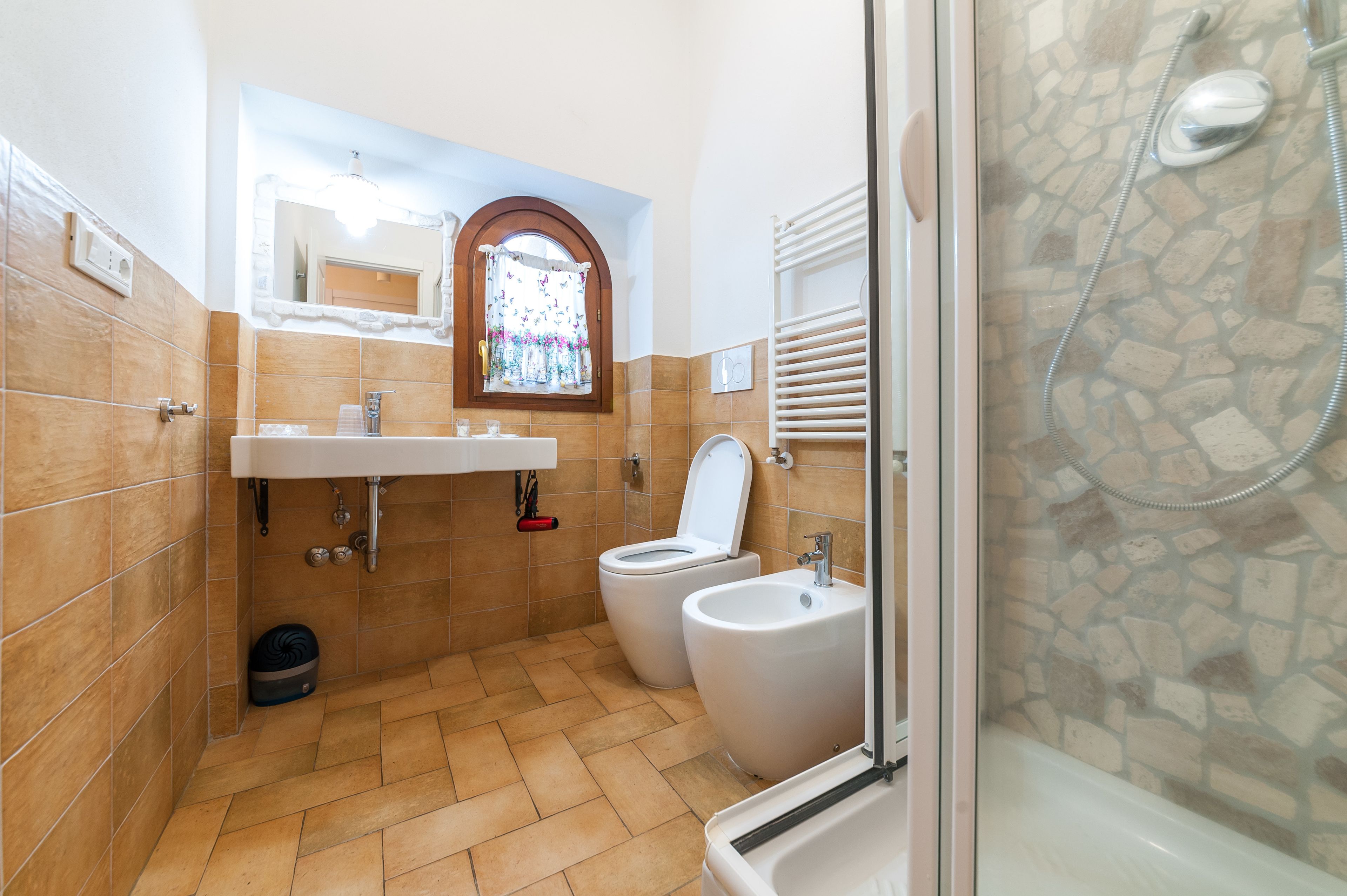 Un bagno con due servizi igienici, un bidet, un lavandino e una zona doccia.
