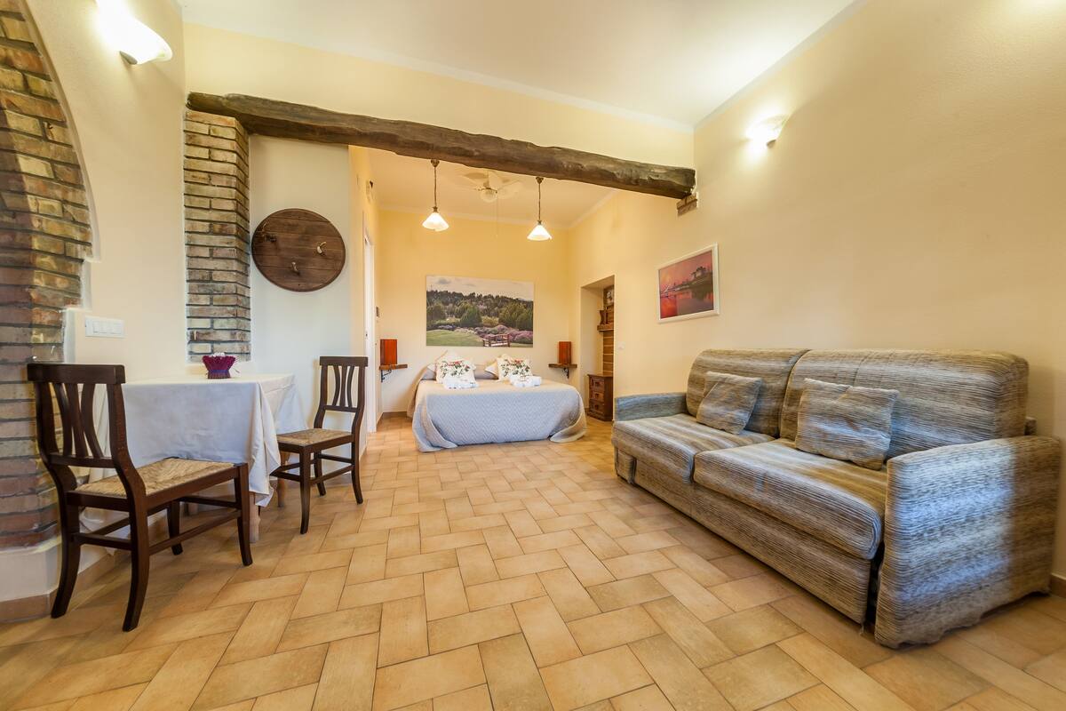 Una habitación acogedora con cama, sofá, mesa de comedor y chimenea.