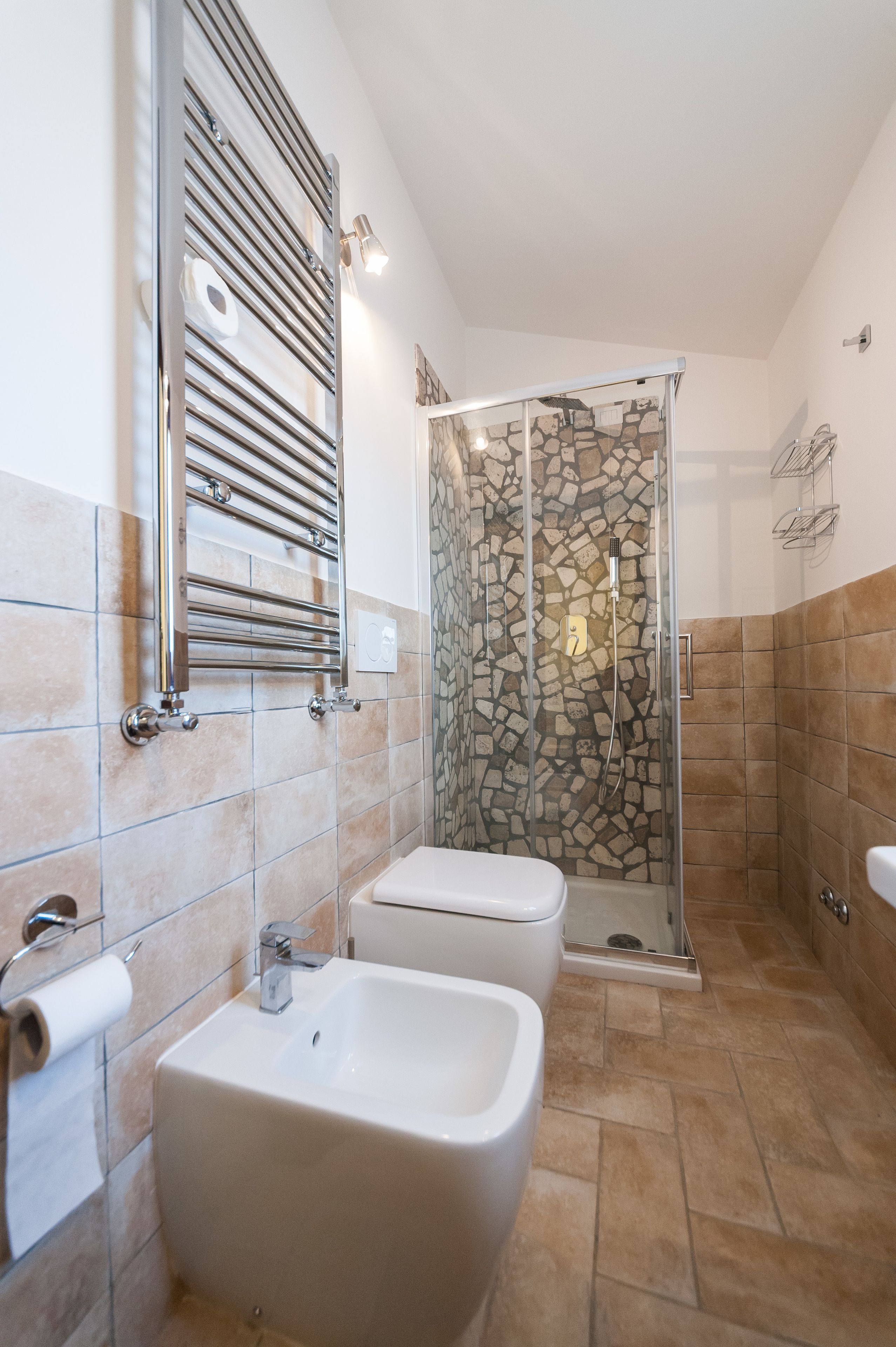 A bathroom with a shower, two sinks, and a toilet.