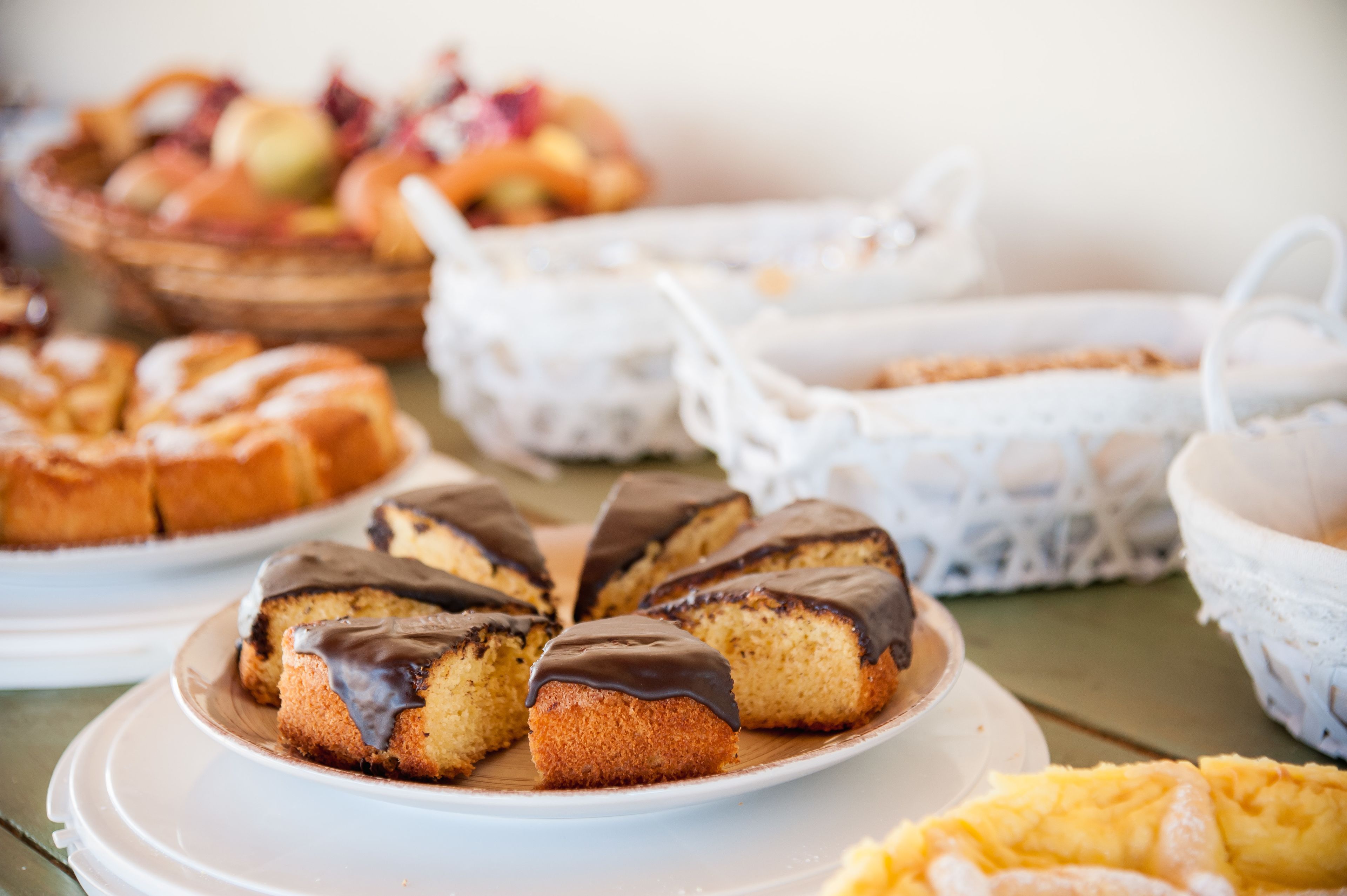 A variety of baked goods on a table, including cakes and pastries.
