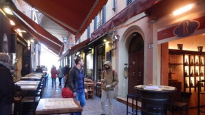 An indoor market with tables and chairs, a wooden barrel, and a sign with the word 'BIRRINA'.