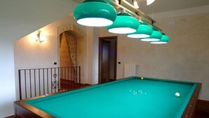 A pool table with a green felt surface, surrounded by a wooden frame. There are three hanging green pendant lights above the table. - Villa Flora Baia degli Ulivi (Santeramo in Colle)