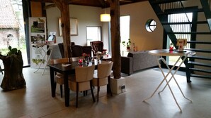Un interior acogedor con una mesa de comedor, sillas, un sofá y una escalera.