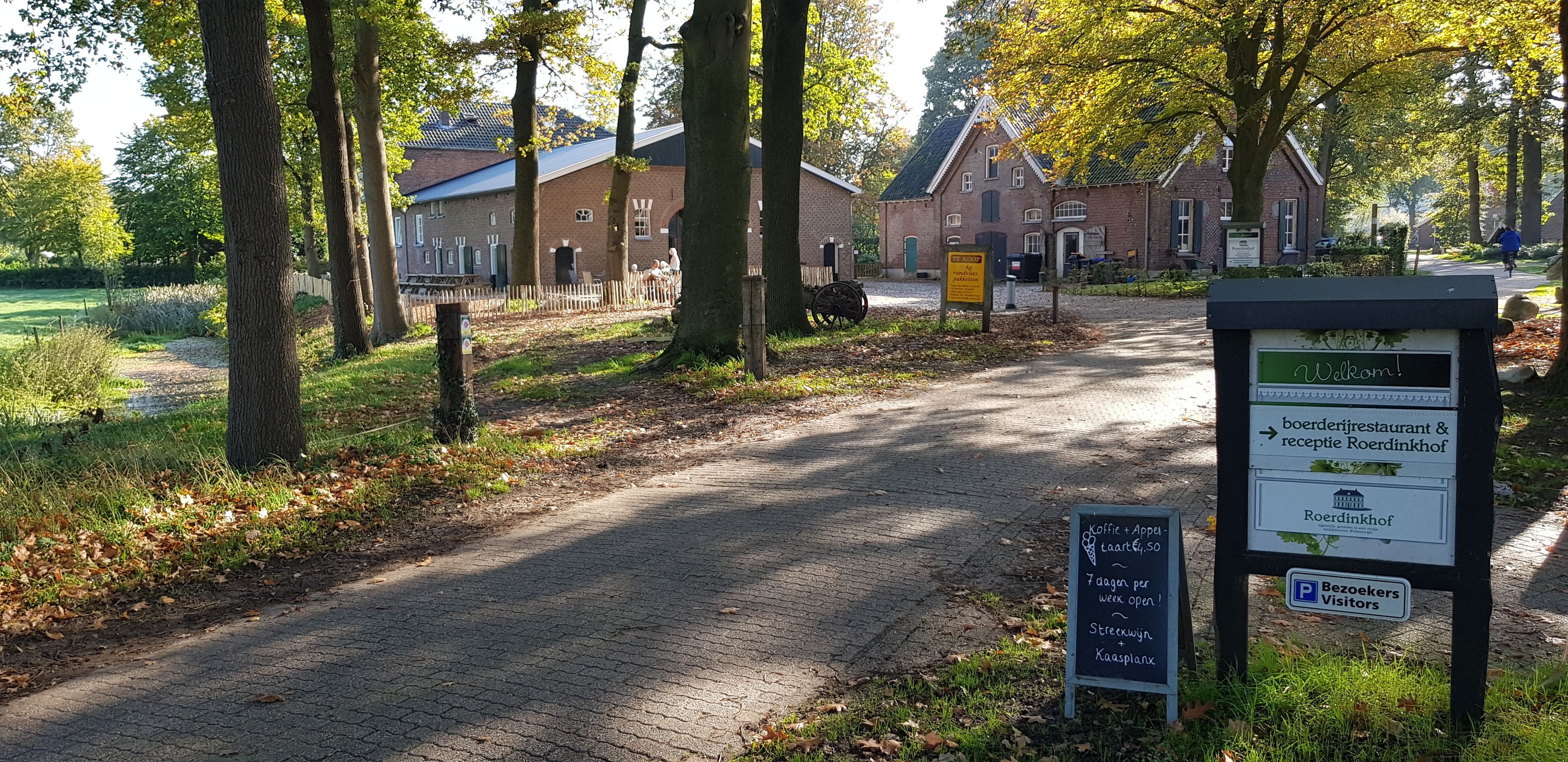 A pathway leading to a traditional brick building with a signboard indicating a restaurant and reception.