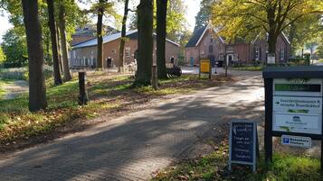 A pathway leading to a traditional brick building with a signboard indicating a restaurant and reception.