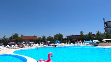 Una piscina al aire libre de temporada, sombrillas