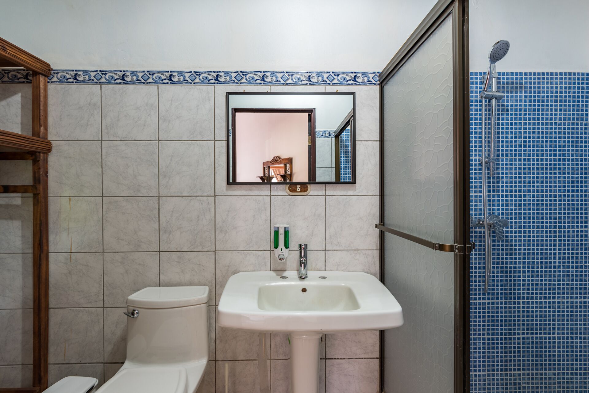 A bathroom with a toilet, sink, and shower.