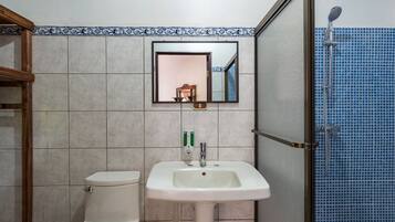 A bathroom with a toilet, sink, and shower.