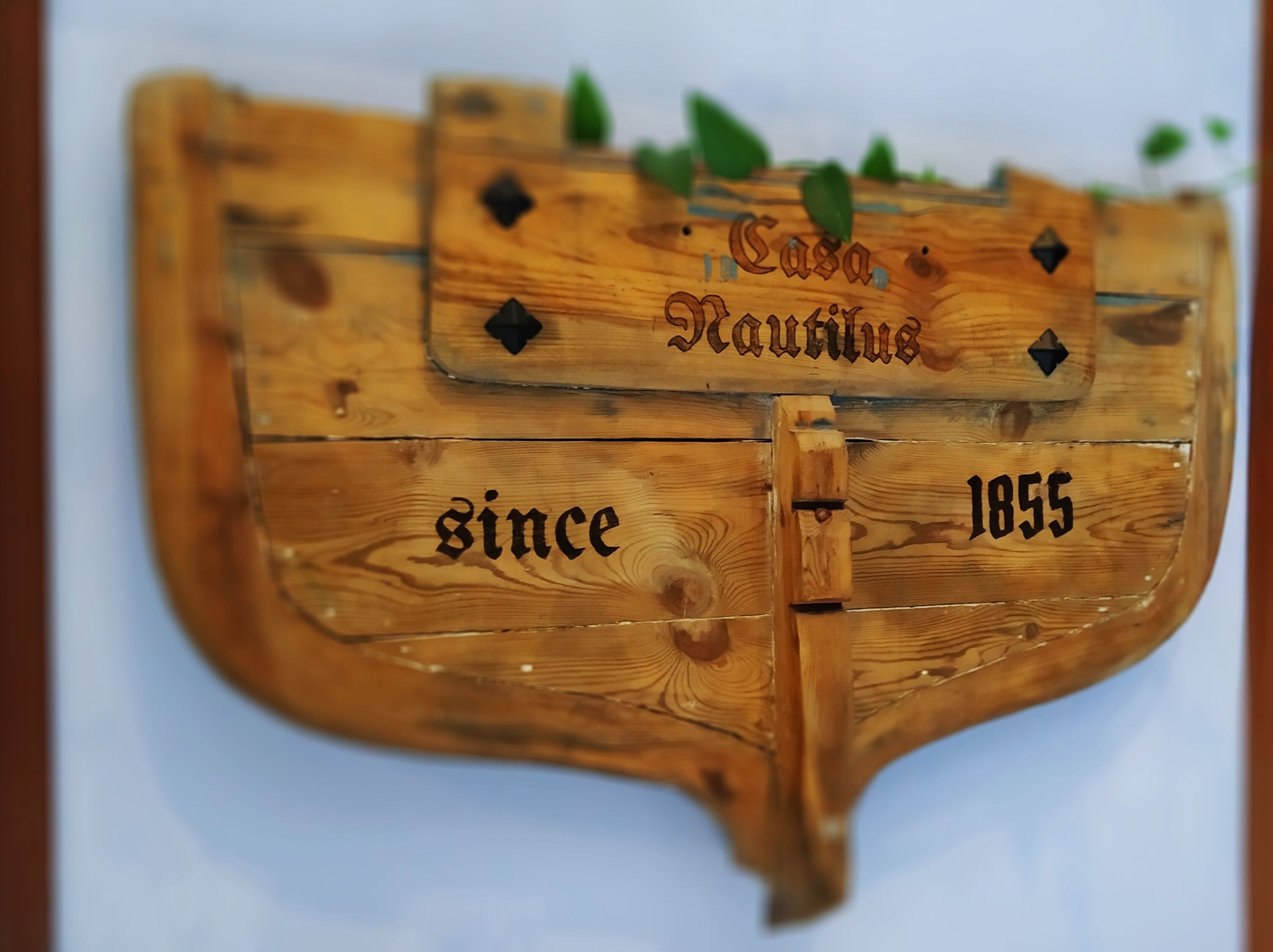 Une plaque en bois portant l’inscription « Casa Nautilus » et l’année « 1855 ».