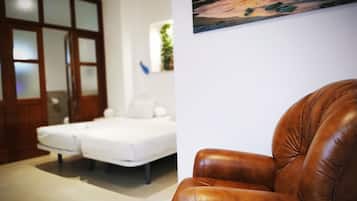 A room with a bed, a brown leather chair, and a painting on the wall.