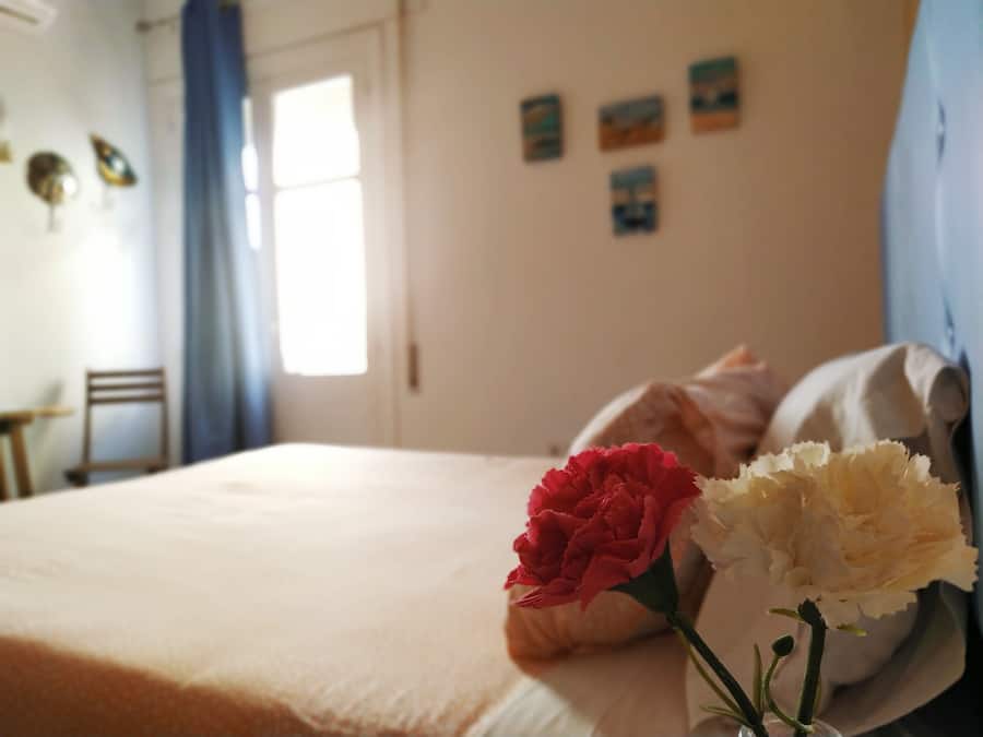 Un dormitorio con una cama, una silla y una ventana.