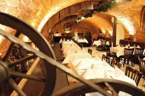 Un interior con arcos de ladrillo, mesas dispuestas para comer y una estructura circular grande.
