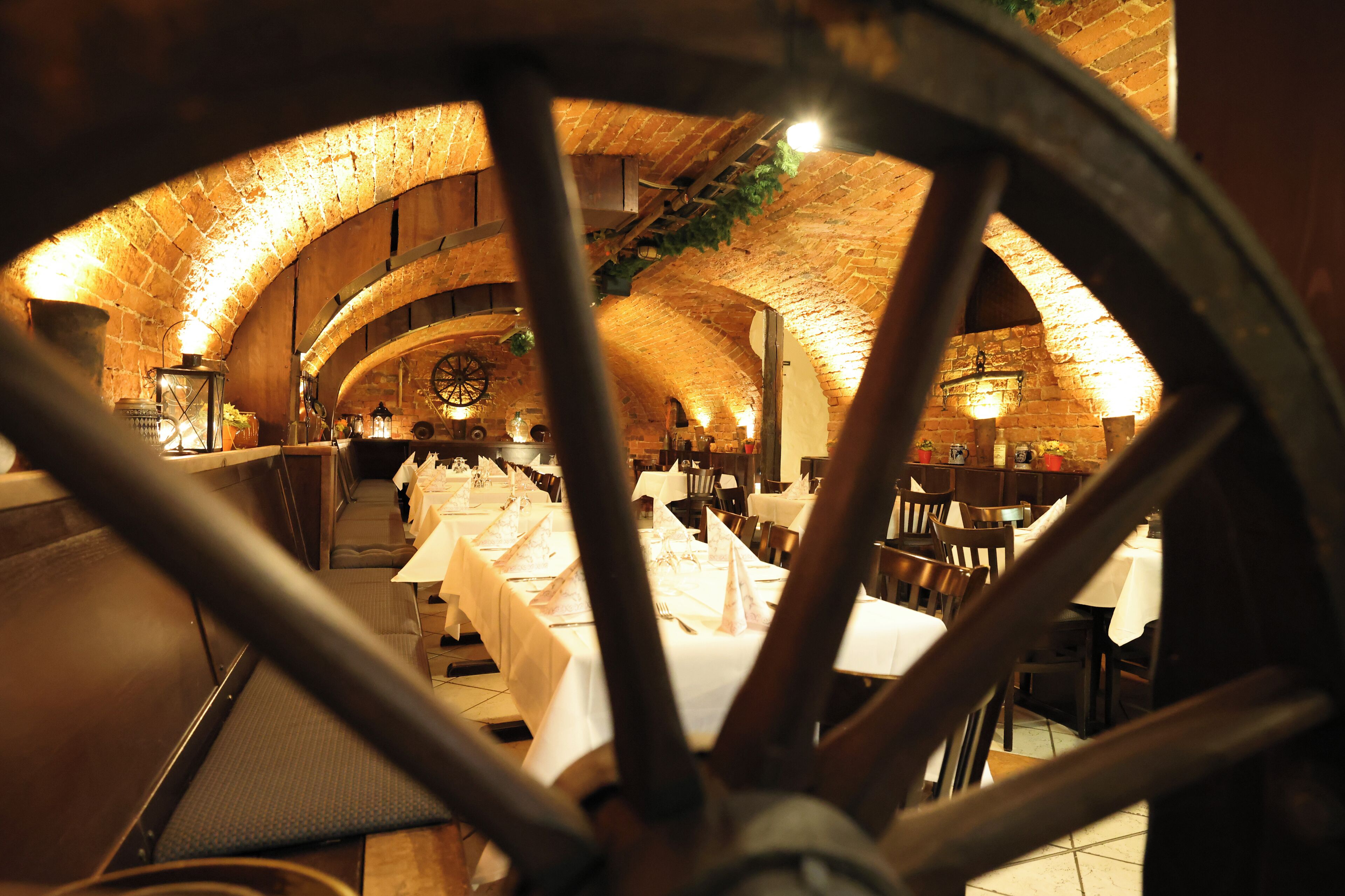 An interior with arched brick ceilings and tables set for dining.
