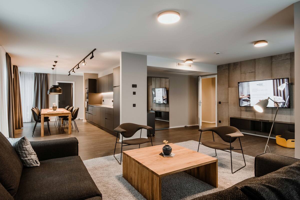 Una sala de estar moderna con sofá, mesa de centro y comedor.