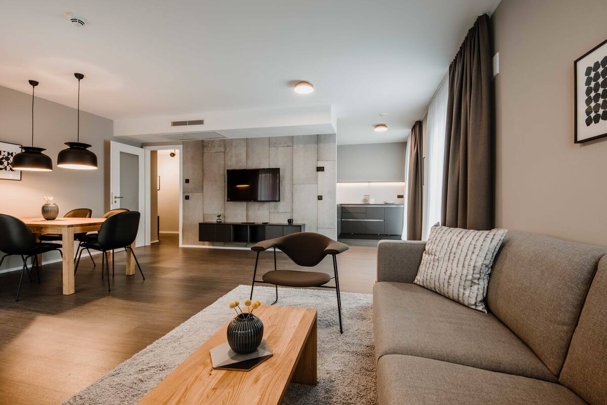 Una sala moderna con sofá, mesa de centro y comedor.