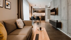 A modern living room with a sofa, coffee table, and a TV mounted on a wall.