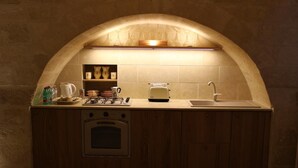 A compact kitchen with a built-in oven, a coffee maker, and a sink under an arched alcove. - Domus Decclesiis (Gravina in Puglia)
