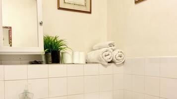 A bathroom with a sink, toilet, and framed floral artwork on the wall.