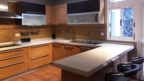Una cocina moderna con una isla grande, electrodomésticos integrados y vistas al exterior a través de una ventana.